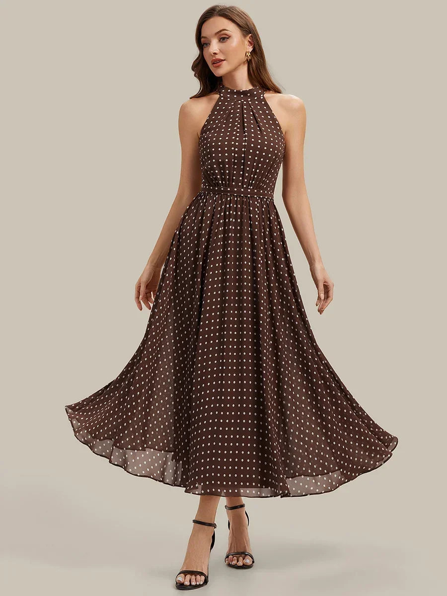 Woman wearing a brown polka dot halter neck midi dress with black strap heels.