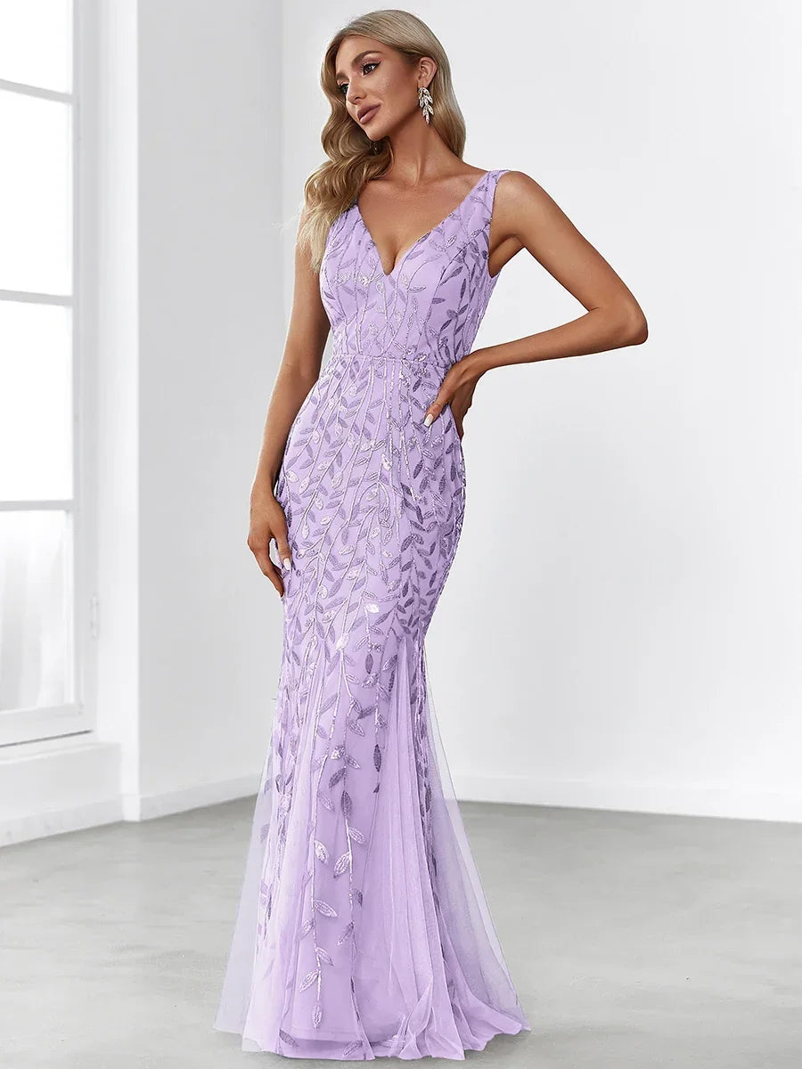 Woman wearing a sleeveless lavender mermaid evening gown with silver leaf embroidery