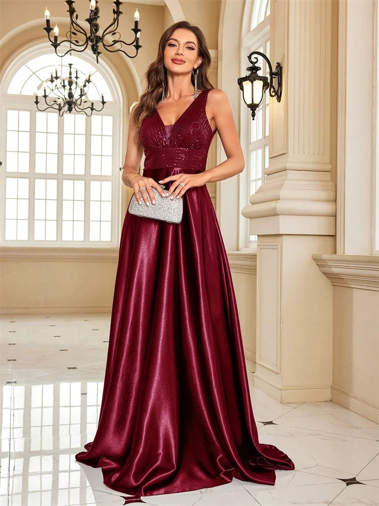 Woman wearing a Dream Designs Boutique sequined V-neck A-line burgundy evening gown.