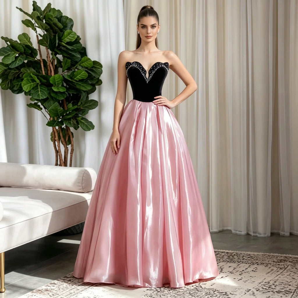 Woman in a strapless black bodice and pink satin A-line evening gown.