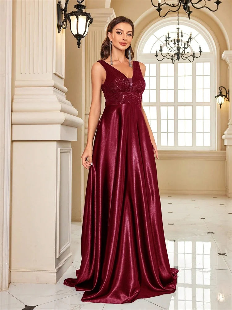 Woman wearing a Dream Designs Boutique sequined V-neck A-line burgundy evening gown.