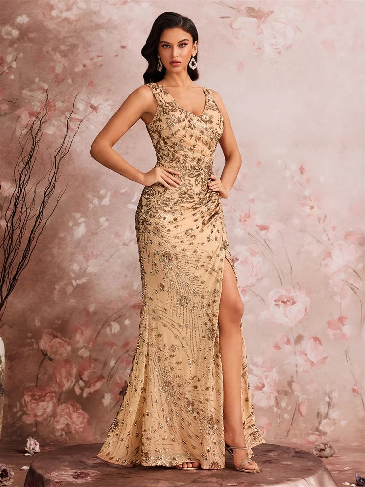 Woman wearing a gold sequined V-neck mermaid evening gown with a high leg slit by Dream Designs Boutique