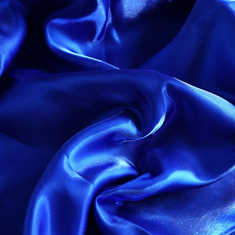 Luxurious royal blue satin fabric with elegant flowing folds and a silky sheen.