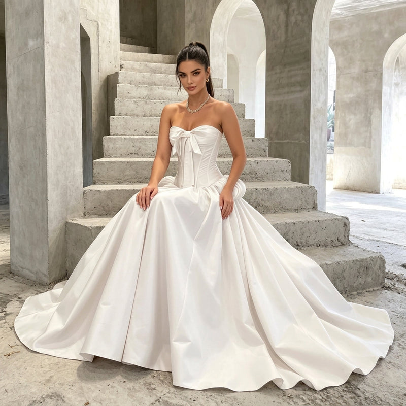 Woman wearing a strapless corset style white wedding gown with a bow and train by AliExpress