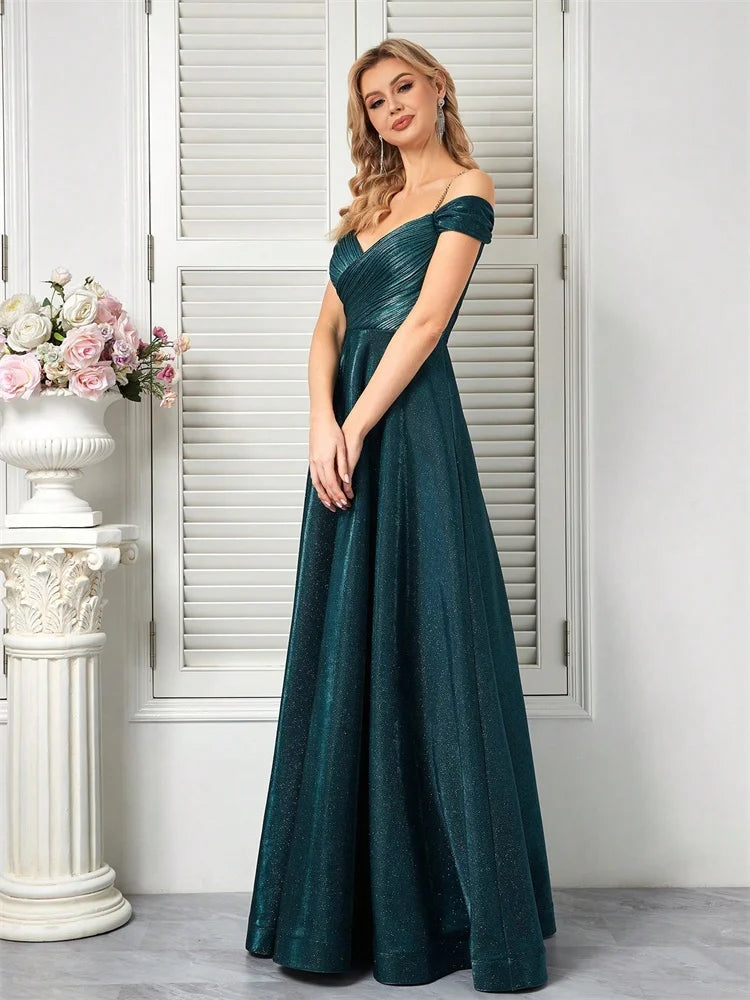 Woman in a sparkly teal A-line evening gown with off-the-shoulder sleeves.