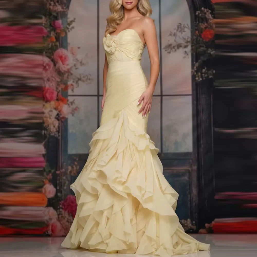Pink strapless organza mermaid gown with tiered floral details by Dream Designs Boutique