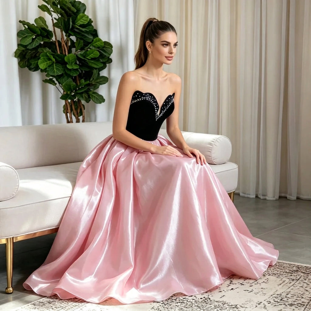 Woman in a strapless heart neckline prom dress with black bodice and pink satin A-line skirt