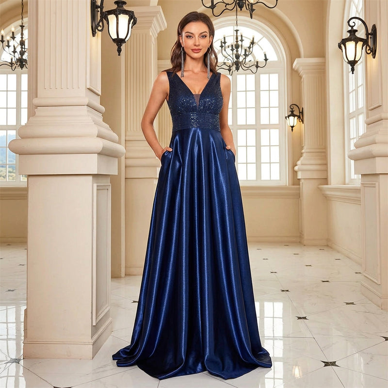 Model wearing a Dream Designs Boutique sequined V-neck A-line navy blue evening gown with pockets.