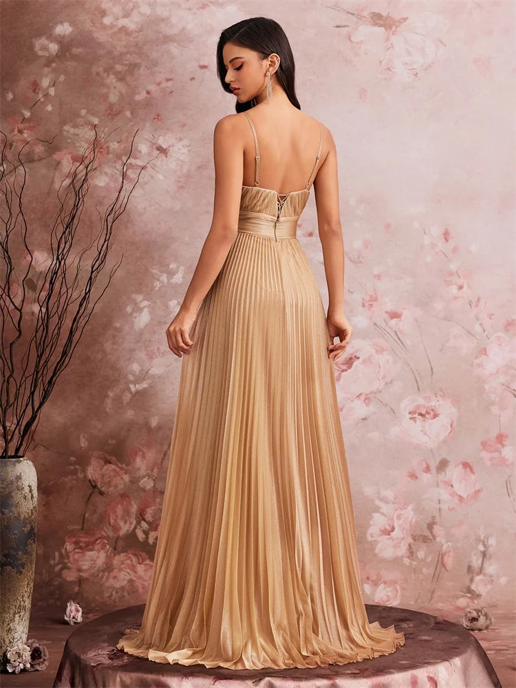 Back view of a woman in a gold pleated chiffon A-line evening gown.