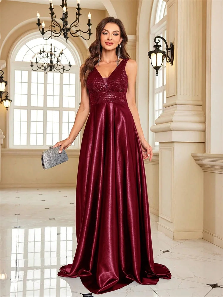 Woman wearing a sequined V-neck burgundy A-line evening gown by Dream Designs Boutique
