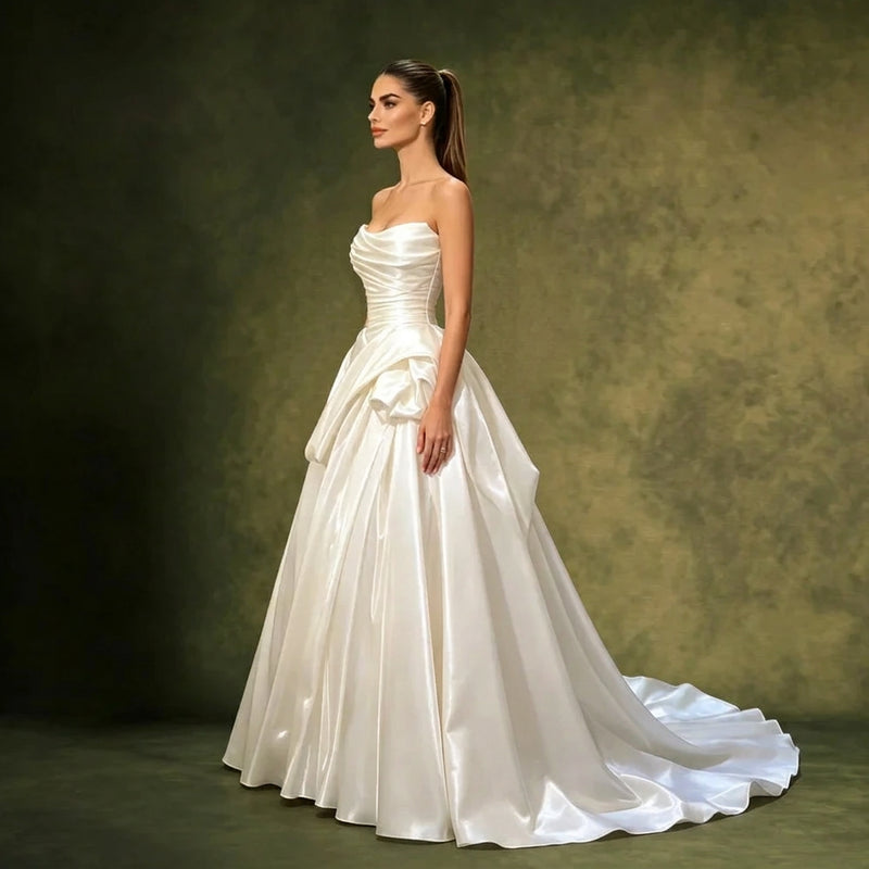 Woman wearing a strapless pleated satin bridal gown by AliExpress against a green background