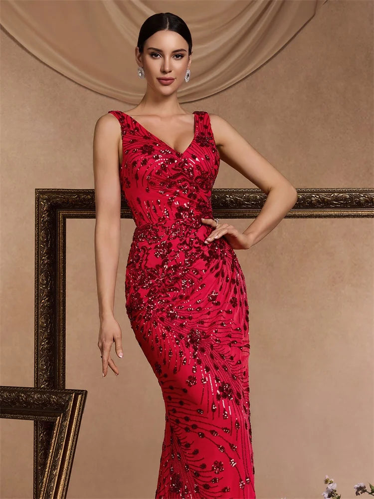 Woman wearing a red sequined V-neck mermaid evening gown by Dream Designs Boutique.