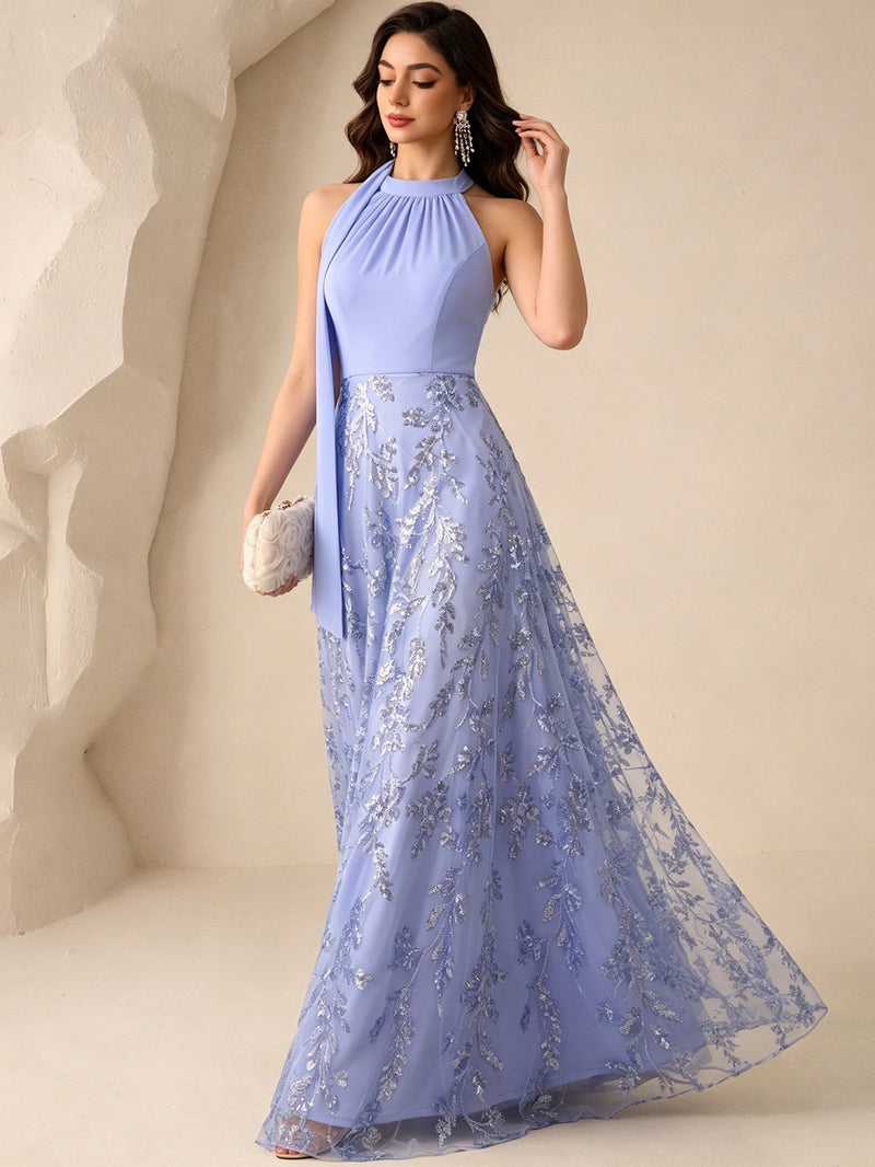 Woman wearing a shimmering blue sequined fit-and-flare evening gown by Dream Designs Boutique