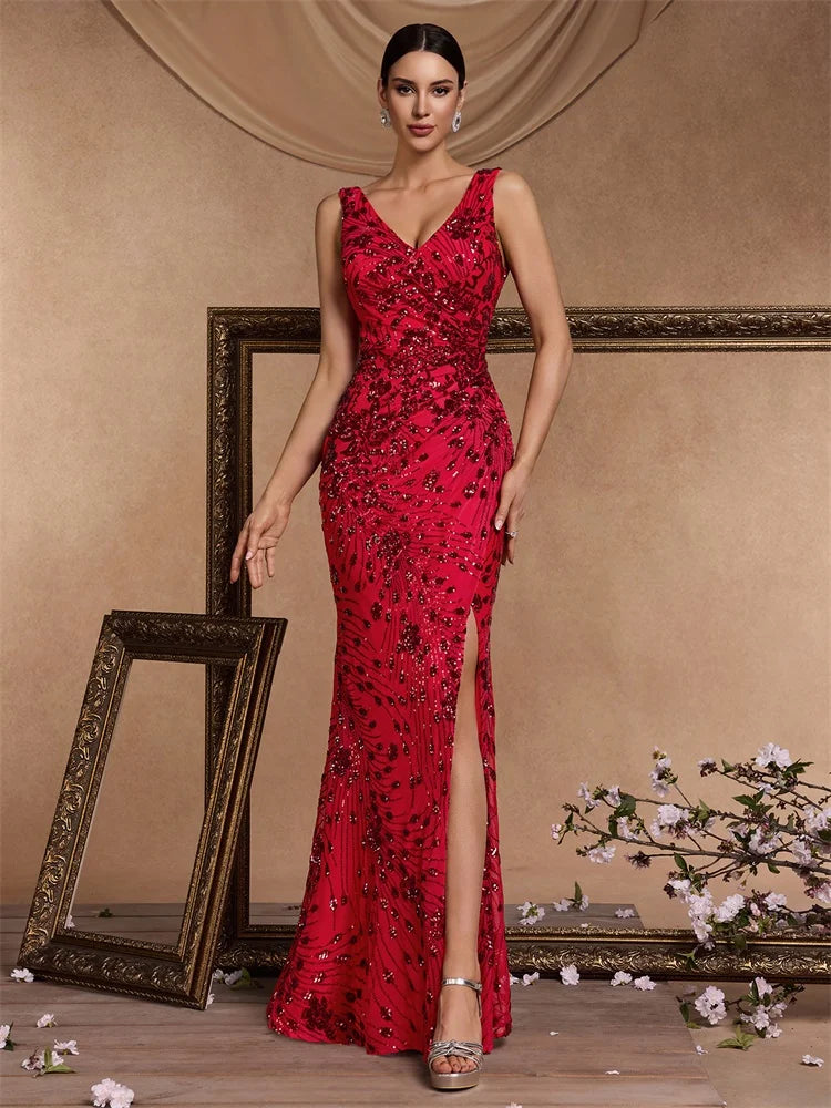 Woman wearing a red sequined V-neck mermaid evening gown with a side slit by Dream Designs Boutique