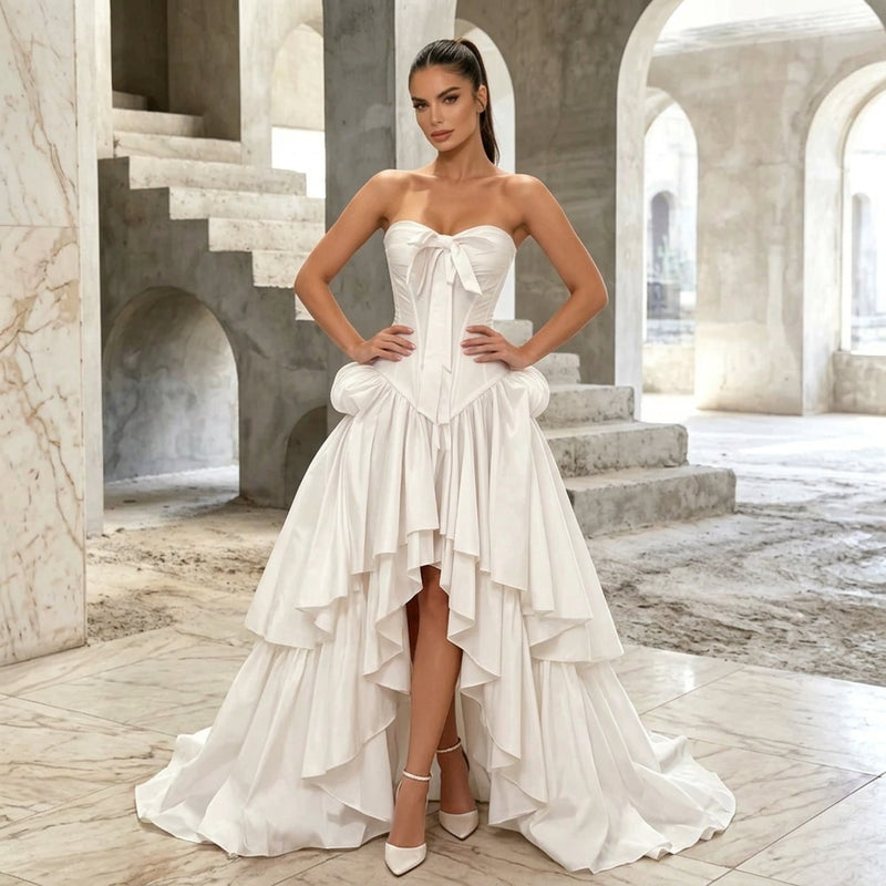 Woman wearing an AliExpress strapless corset style white wedding gown with a high-low train.