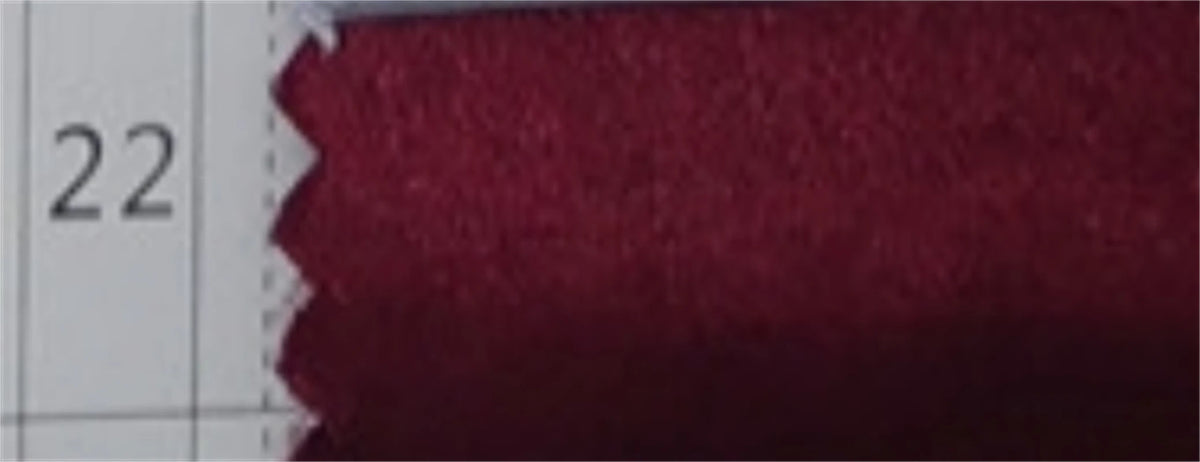 Close-up texture of a maroon fabric for an off the shoulder formal evening gown.