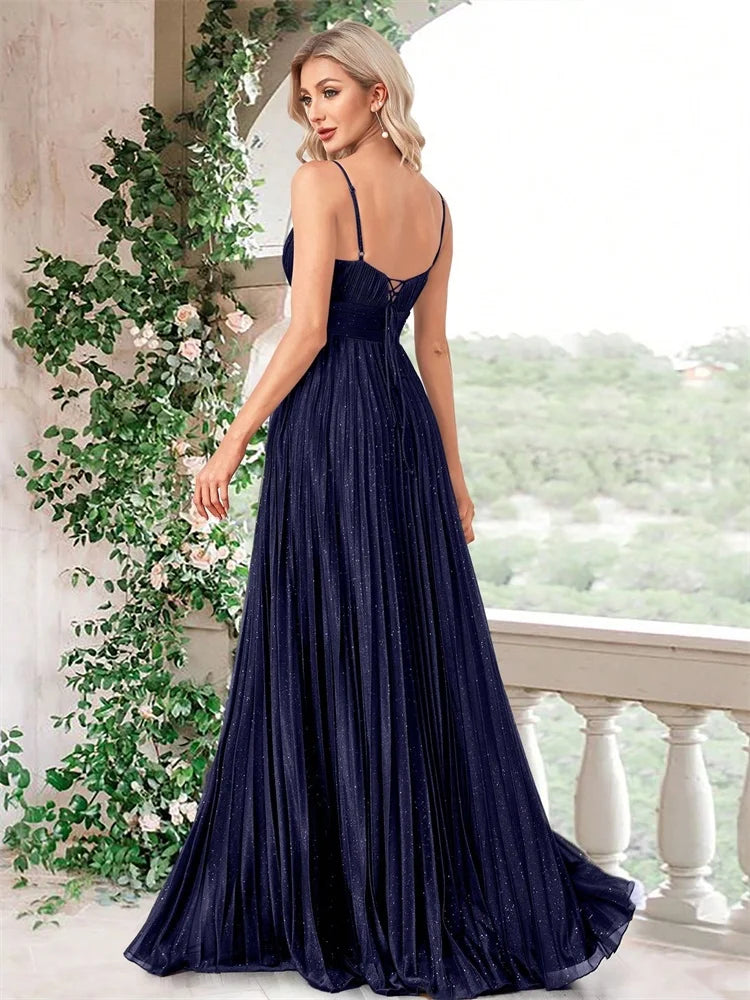 Woman in Dream Designs Boutique navy blue chiffon A-line evening gown with deep V-neck back.