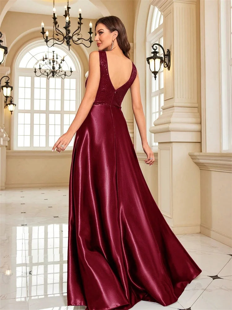 Woman in a burgundy sequined V-neck A-line evening gown by Dream Designs Boutique