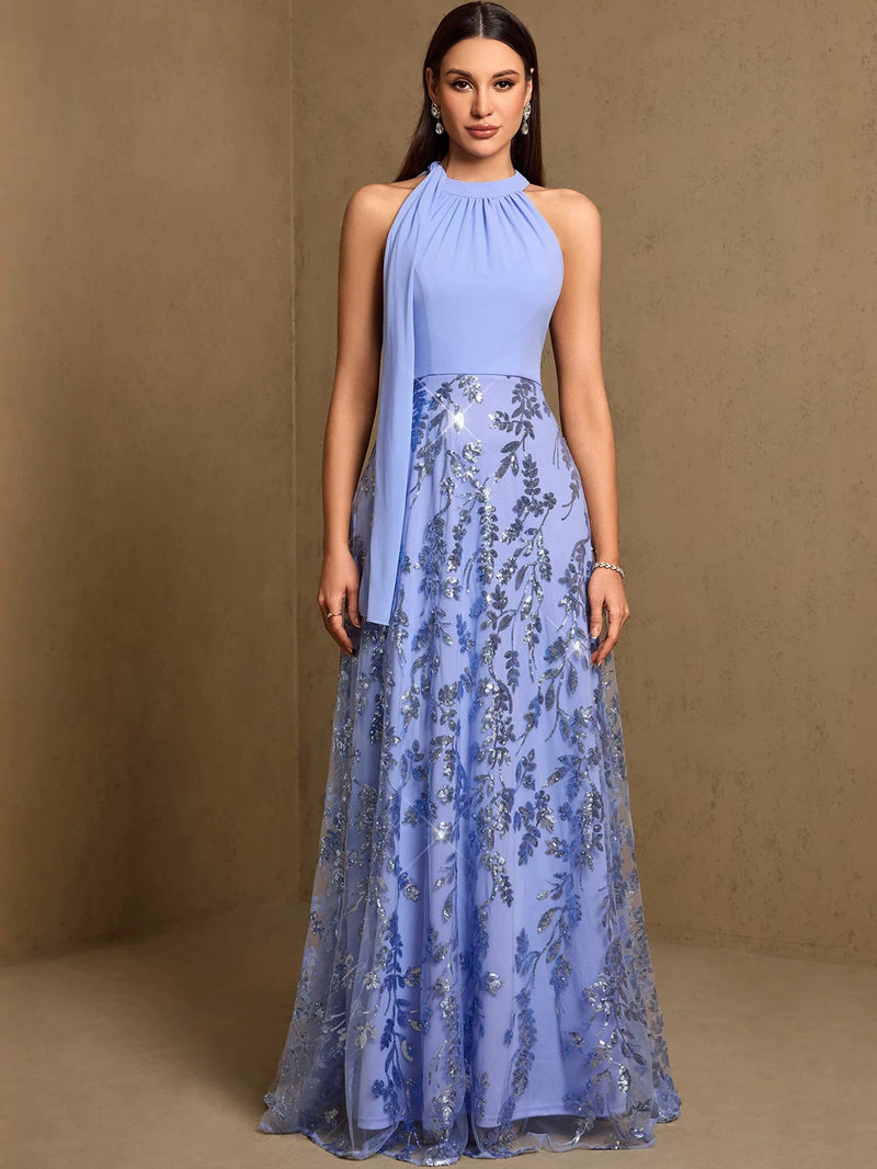 A woman wearing a shimmering blue sequined fit-and-flare evening gown by Dream Designs Boutique.